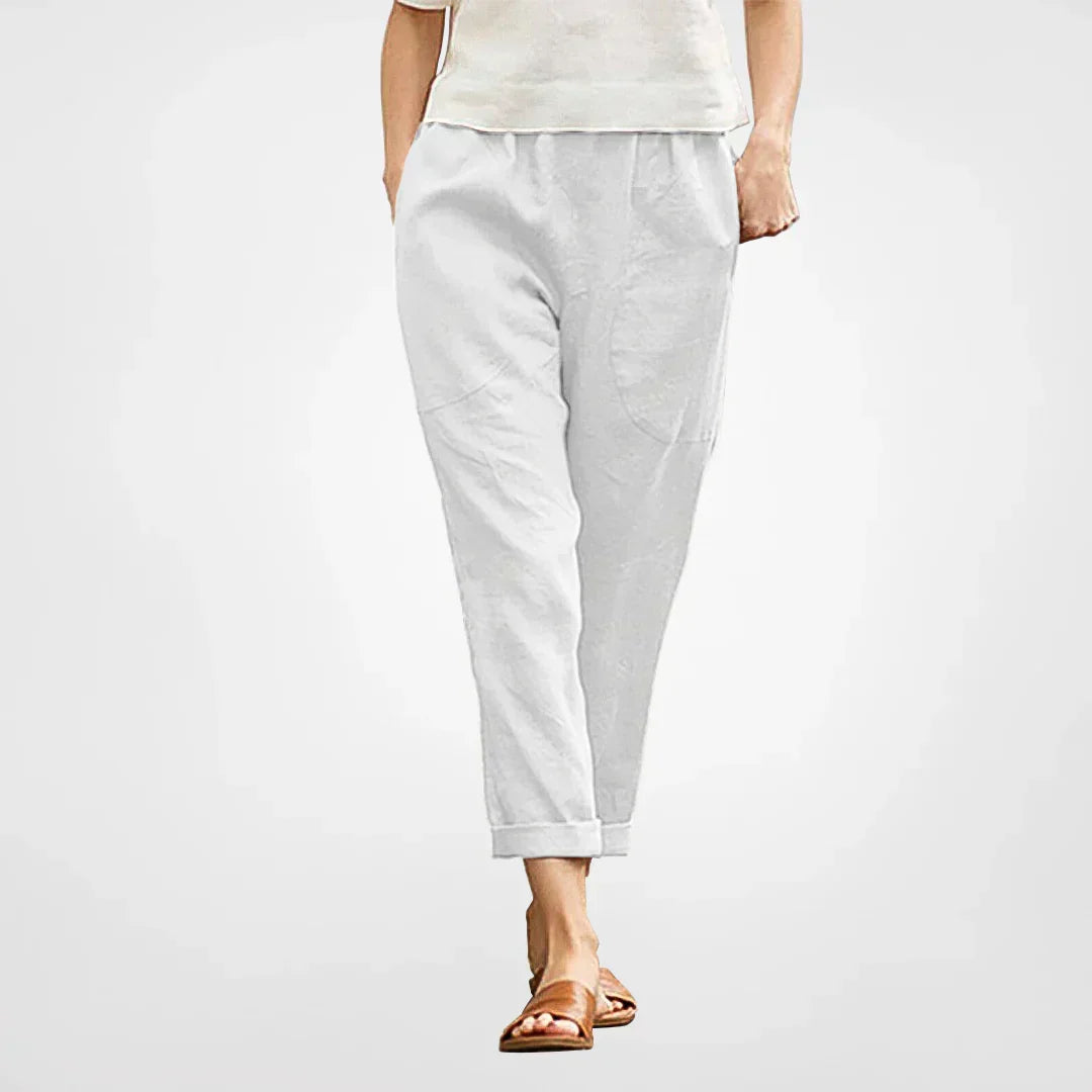 Woman wearing white cropped tapered trousers with elastic waist and side pockets