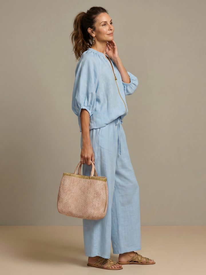 Side profile view of woman in light blue co-ord set with wide leg trousers