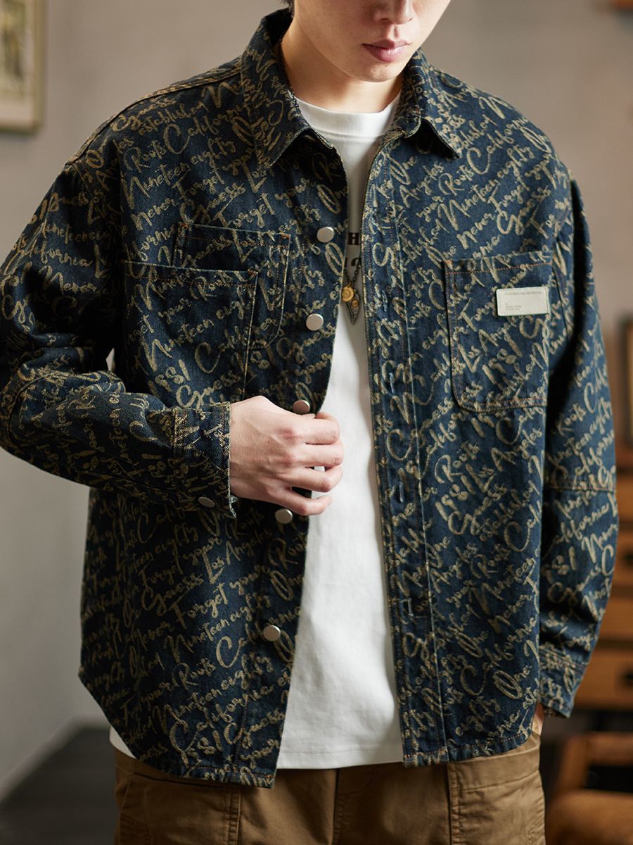 Close up of chest pocket and metal button hardware on mens script denim jacket