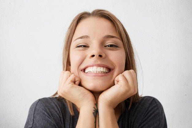 Smiling woman showing natural-looking teeth with cosmetic dental prosthesis