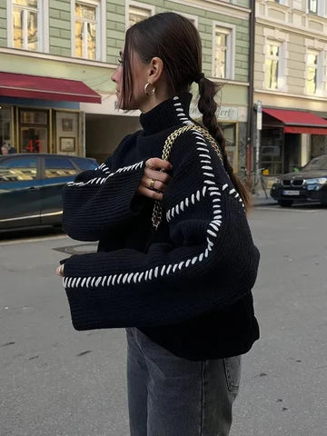 Flat lay of women's black pullover sweater styled for winter fashion