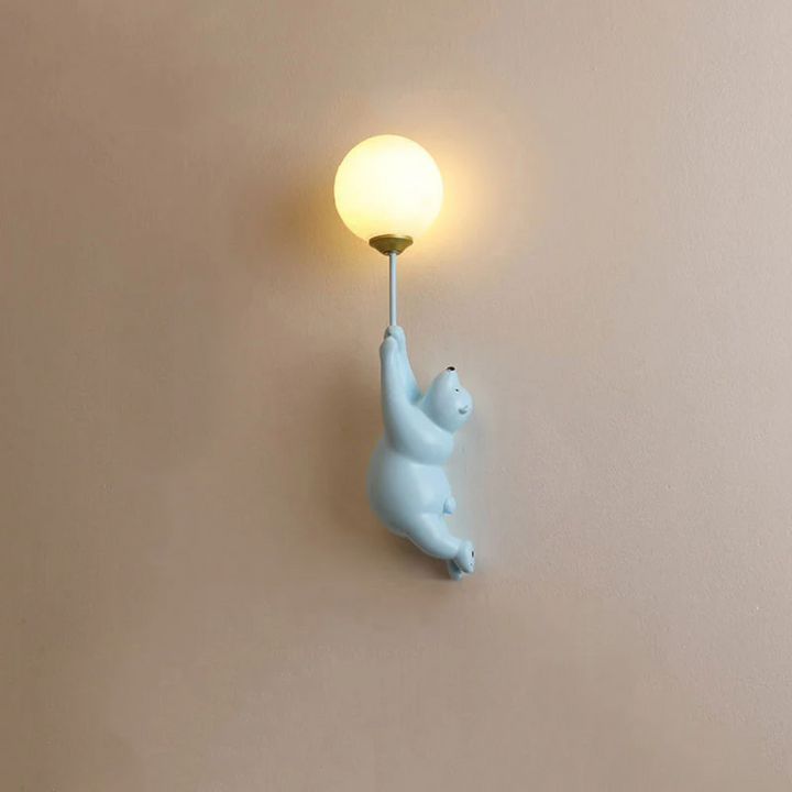 Full view of the blue bear wall lamp mounted on a neutral wall