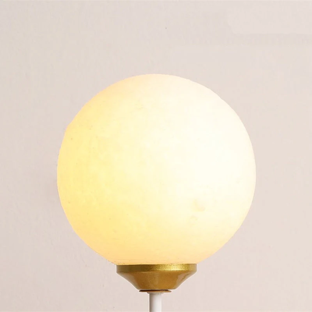 Close-up of the glowing spherical lamp shade on the wall fixture