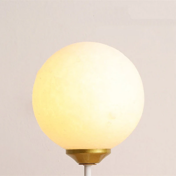 Close-up of the glowing spherical lamp shade on the wall fixture