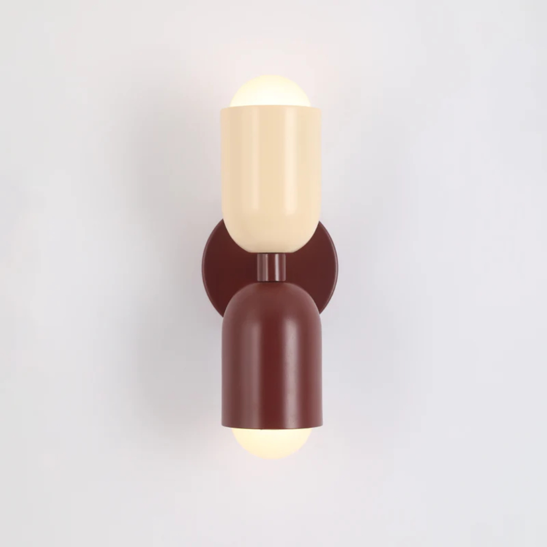 Close-up of designer LED wall sconce showing sleek minimalist metal fixture construction