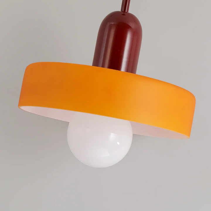 Warm and inviting bedroom light fixture hanging above a bedside table