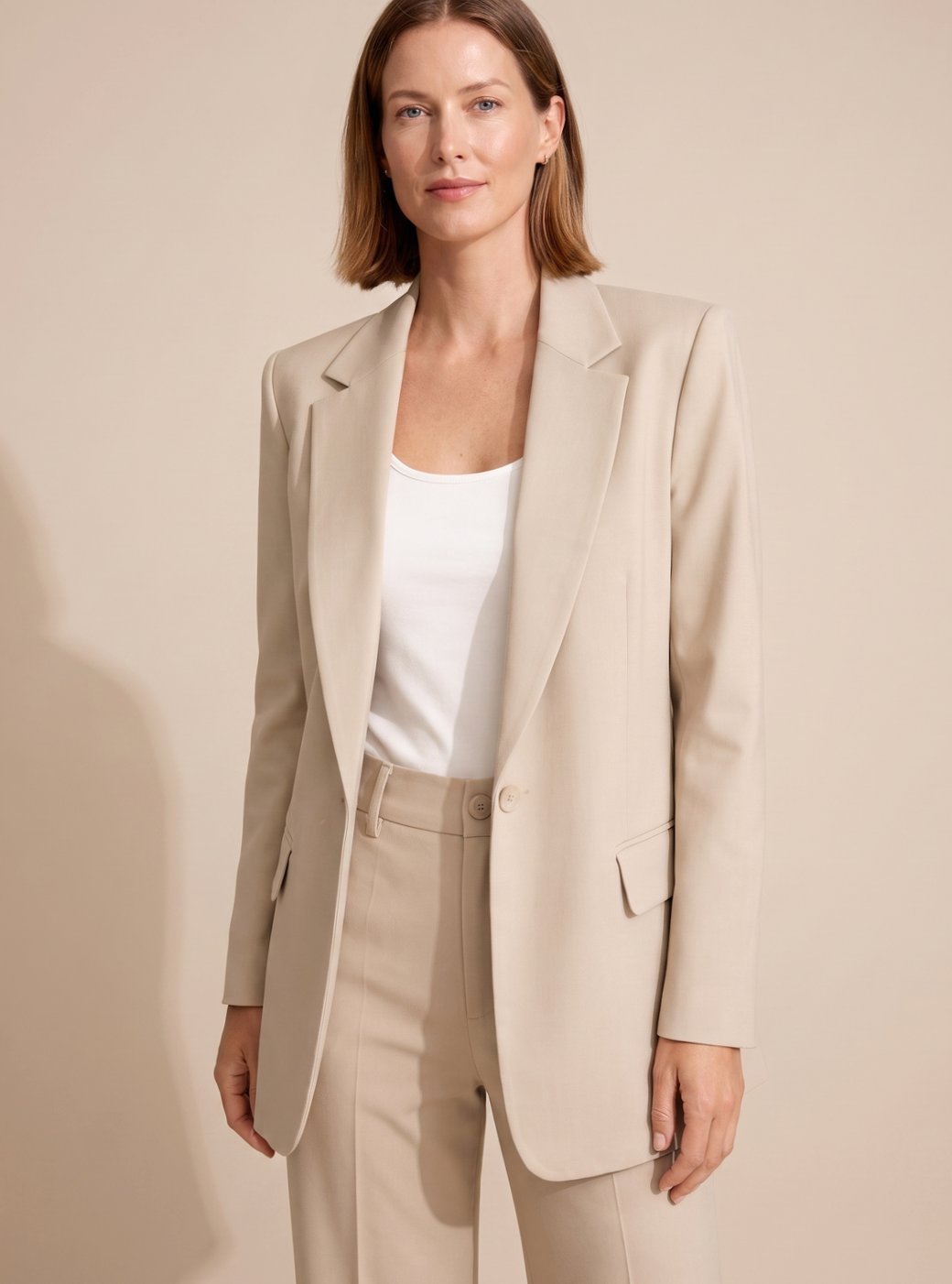 Front view of woman wearing beige Serena blazer and flared trousers set