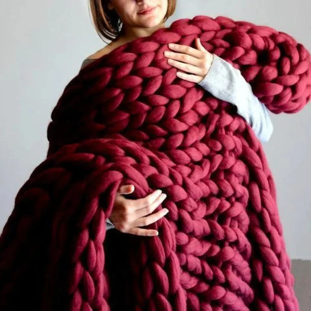 Person knitting with thick wool-like yarn for cozy home projects