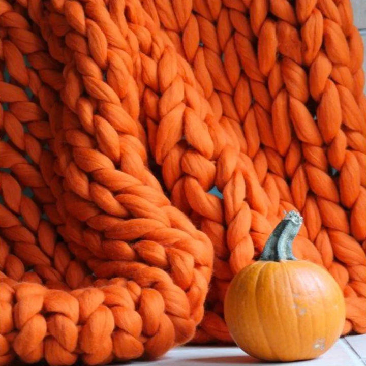 Finished DIY chunky blanket draped over a modern sofa