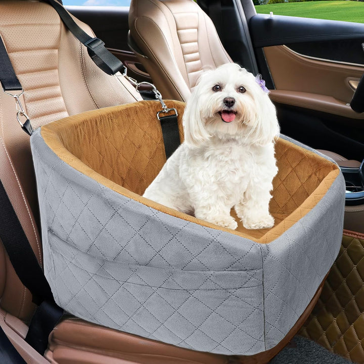 Small white dog relaxing in a grey and brown two-tone dog car seat inside a car.