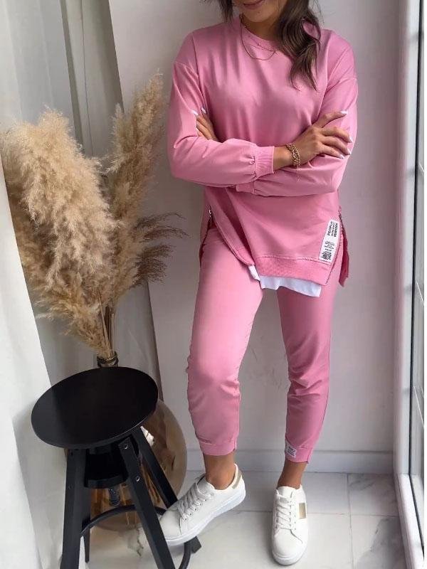 Woman wearing pink Marley loungewear set paired with white sneakers indoors