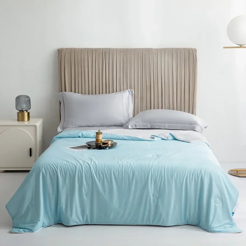 Sky blue double-sided cooling blanket displayed neatly on a modern bed setup