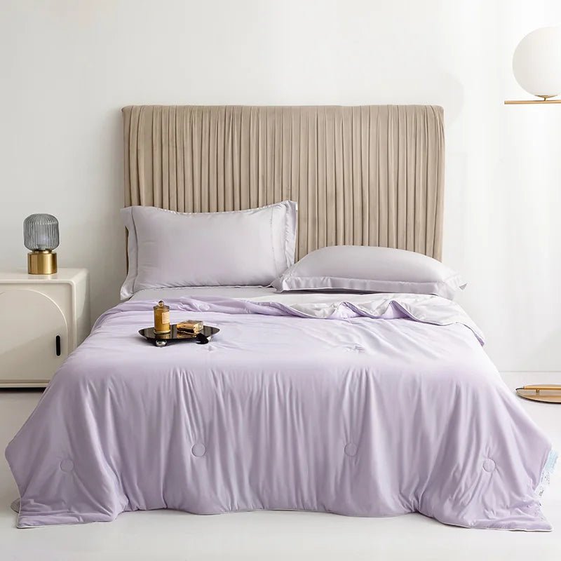 Double-sided cooling blanket draped across a modern bed for hot sleepers