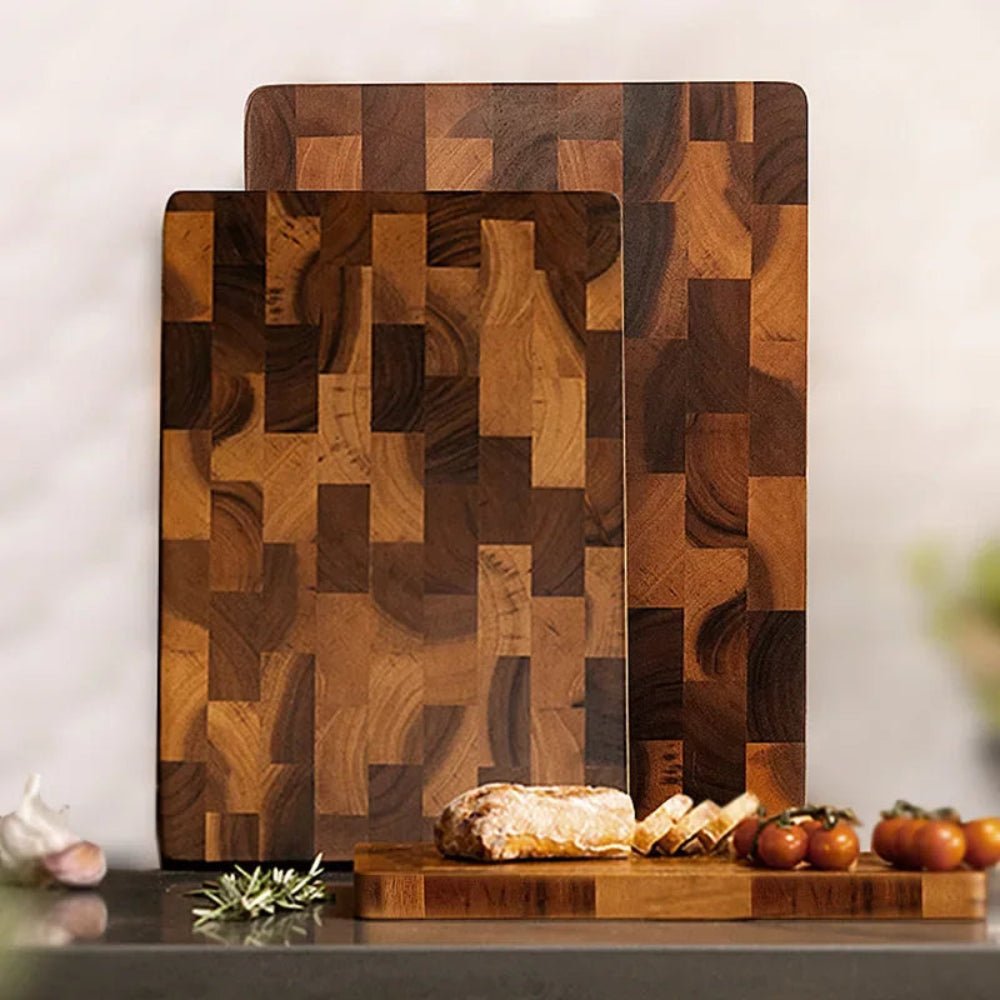 Three wooden cutting boards of various sizes displayed upright with bread and tomatoes
