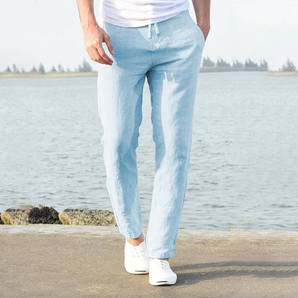 Man wearing light blue lightweight drawstring trousers by the water