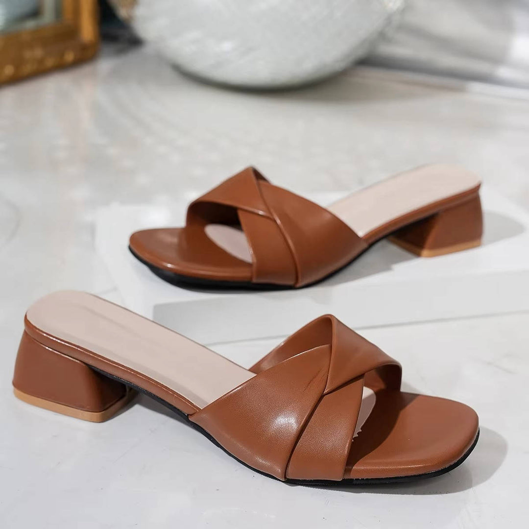 Pair of brown low block heel mule sandals displayed side by side on a clean surface.