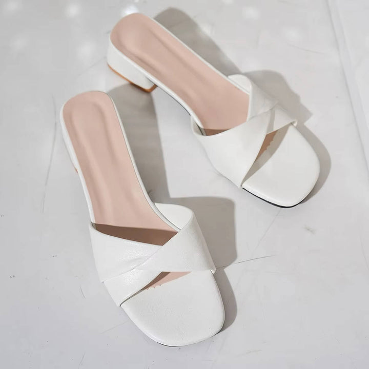 Angle shot of twisted strap mule sandals paired with summer outfit