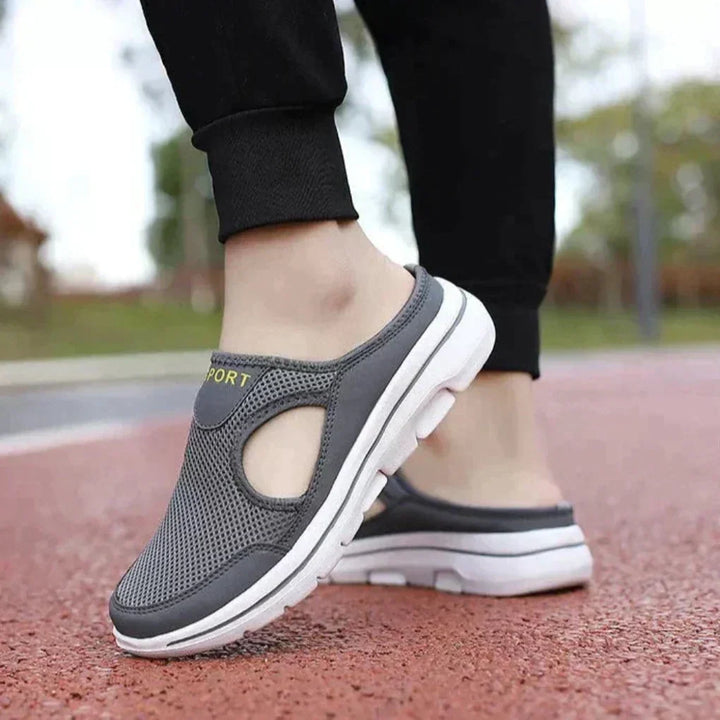 Side view of grey orthopedic slip-on sneaker mules on walking track