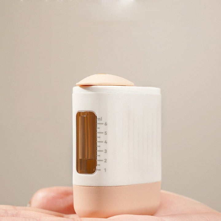 Close-up view of the rechargeable scalp massager showing the built-in liquid applicator and measurement scale