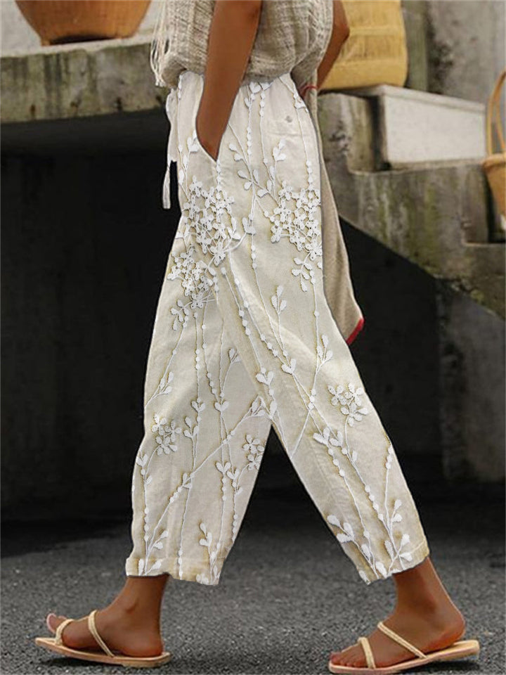 Woman wearing beige trendy printed trousers with botanical pattern