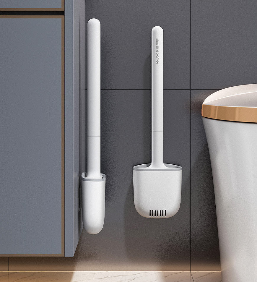 White silicone toilet brush mounted on bathroom wall next to a toilet