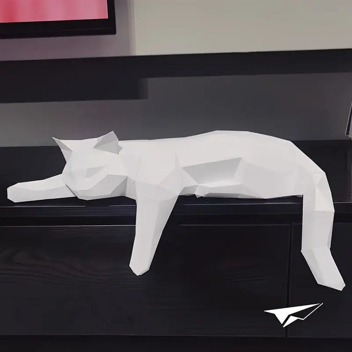 White geometric paper cat statue displayed on a dark surface