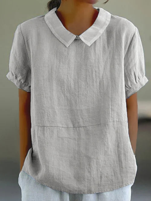 Close-up of fabric and neckline on women's elegant short sleeve office wear top