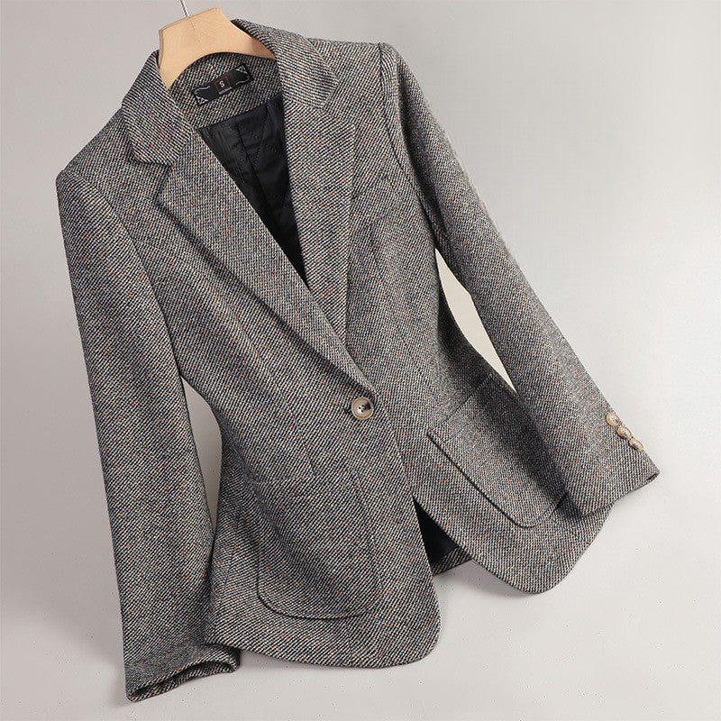 Gray tailored women's blazer jacket hanging on a wooden hanger
