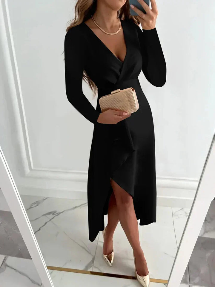 Woman wearing black long sleeve evening dress holding a clutch