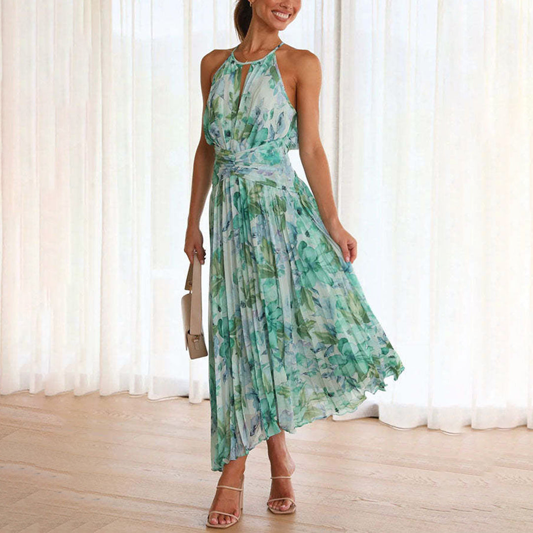 Front view of a woman wearing a green floral halter maxi dress with an asymmetric hem