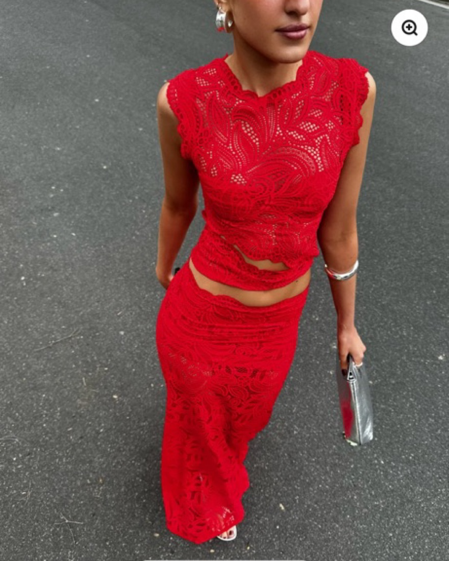 Full-length view of the elegant red two-piece outfit worn outdoors, showcasing the matching top and maxi skirt.