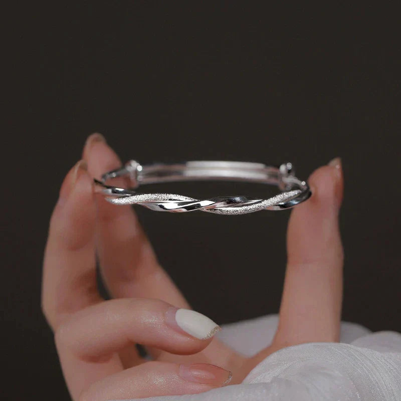Close-up view of the intricate silver bracelet held in hands