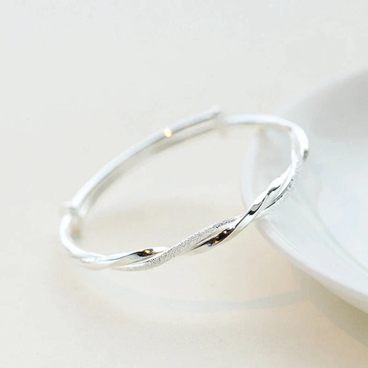 Silver bracelet displayed on a white surface highlighting the polished finish