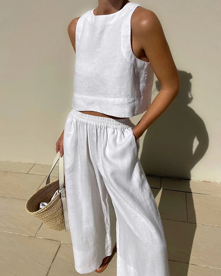 Woman wearing a white sleeveless top and matching trousers two-piece set