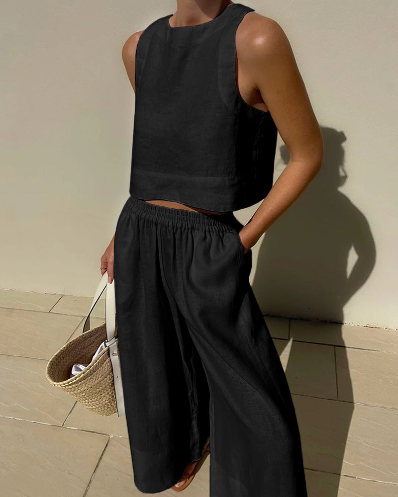 Woman wearing a black sleeveless top and matching trousers two-piece set