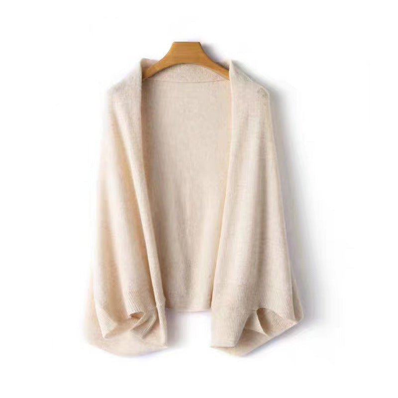 Women's elegant warm soft shawl wrap in beige hanging on a wooden hanger