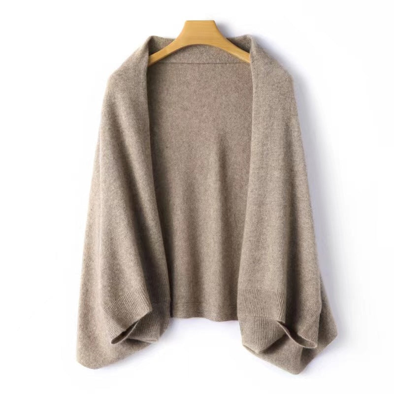 Women's elegant warm soft shawl wrap in tan hanging on a wooden hanger