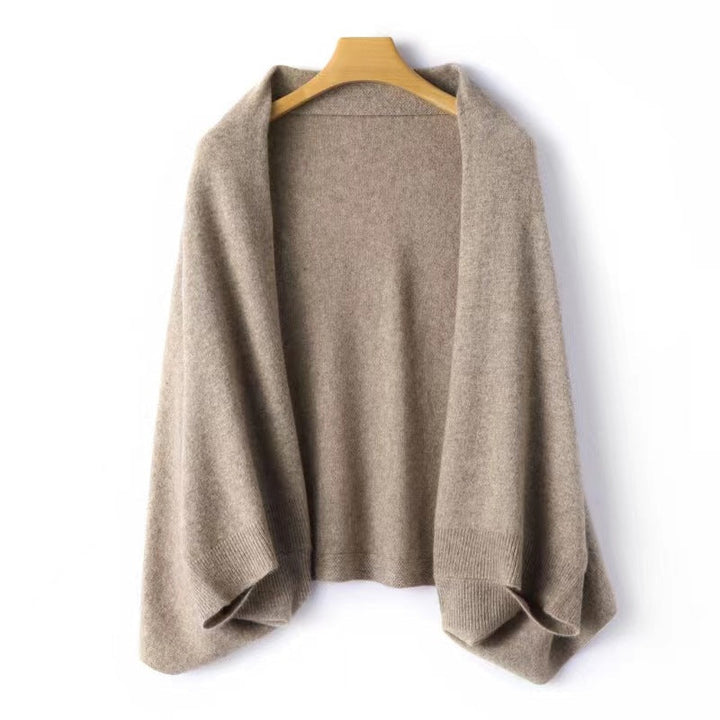 Women's elegant warm soft shawl wrap in tan hanging on a wooden hanger