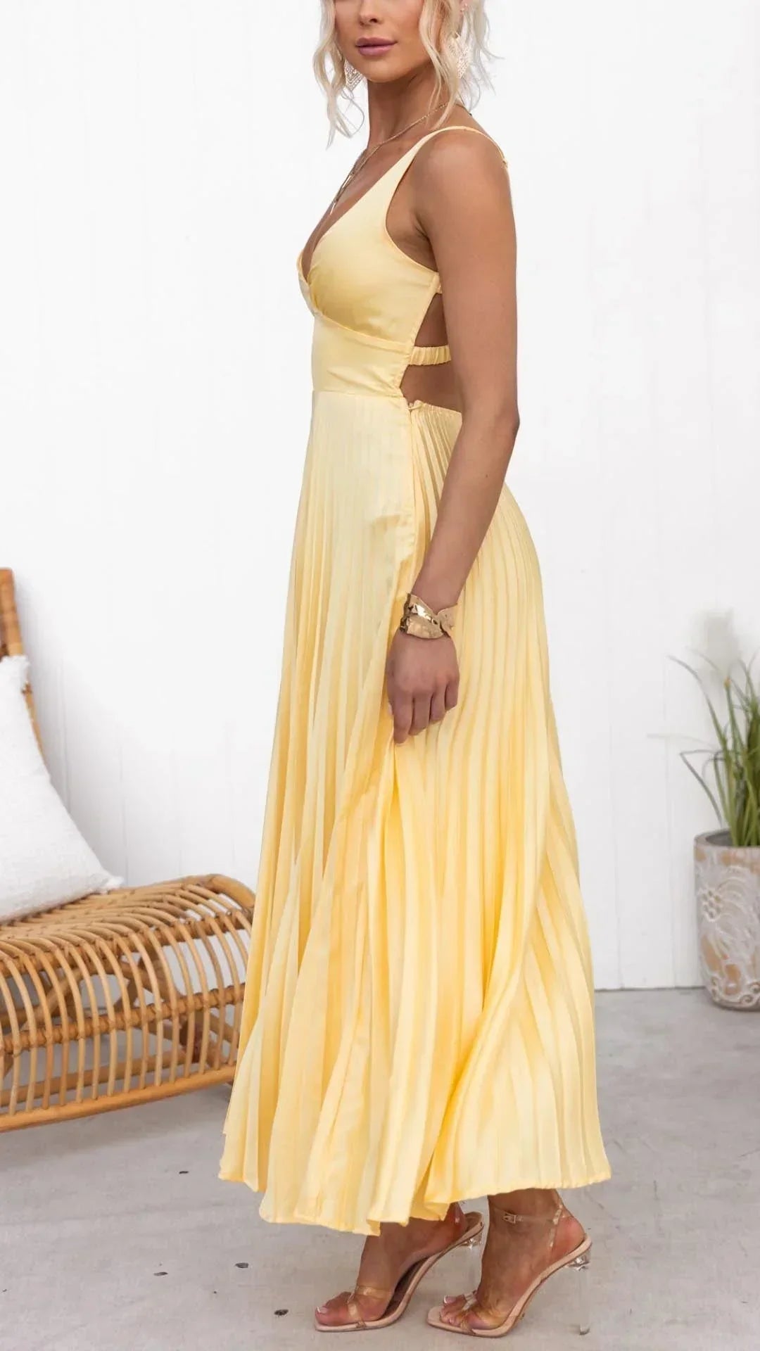 Side view of yellow maxi dress showing crossover back straps and pleated flow