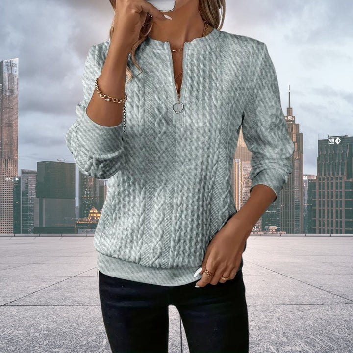Woman posing in a grey cable knit zip up sweater outdoors