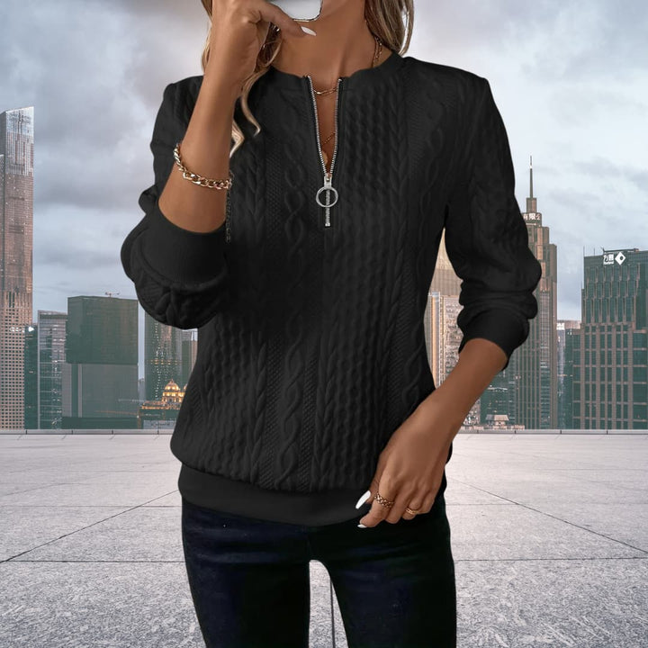 Woman showcasing a black cable knit zip up sweater with front zipper detail