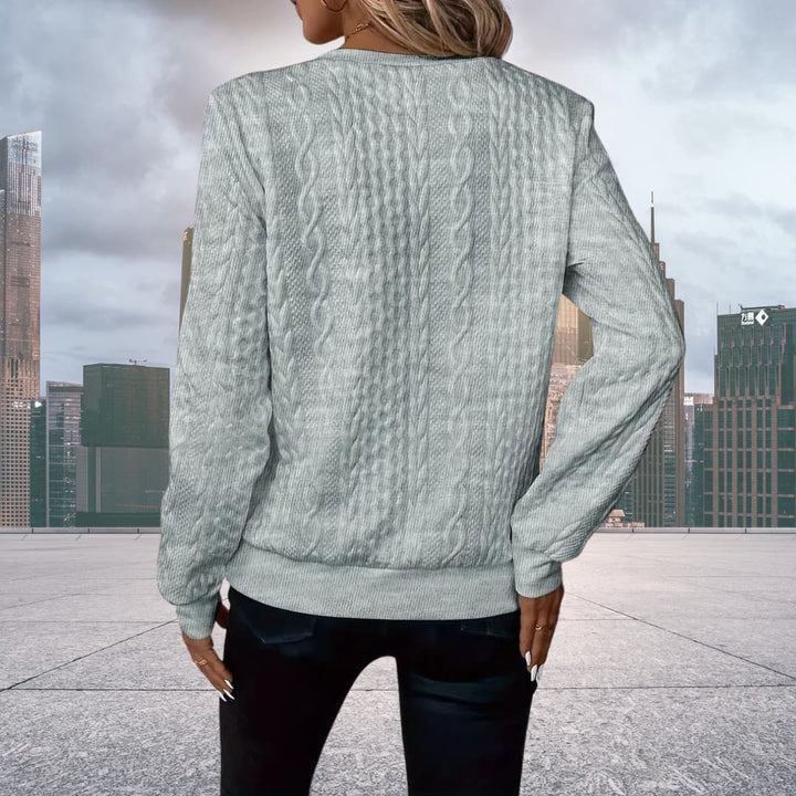 Flat lay of women's cable knit zip up sweater styled for casual wear