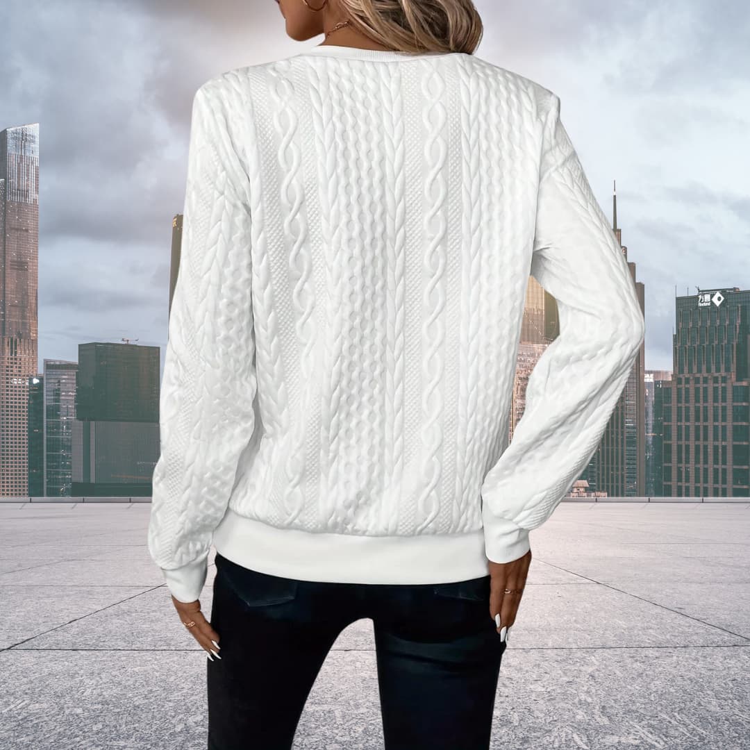 Close up of metal zipper hardware on women's cable knit cardigan
