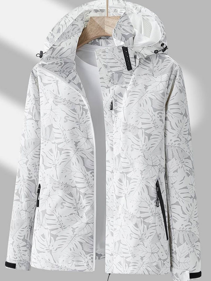 White women's waterproof hooded jacket with botanical print on display