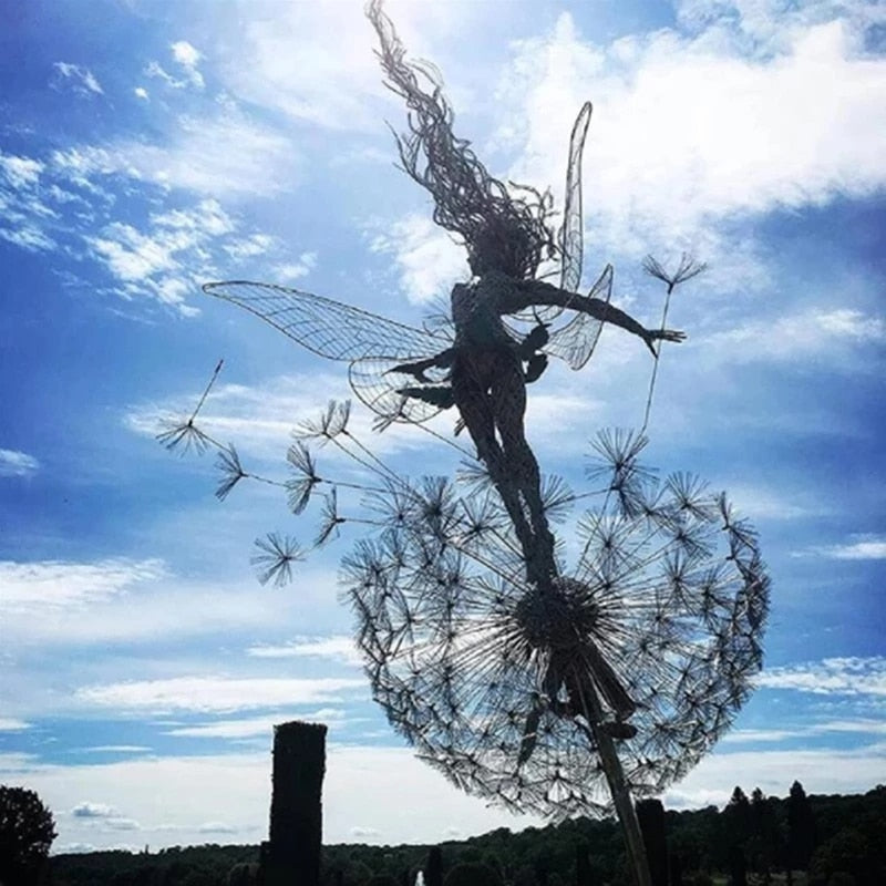 Enchanting fairy garden sculpture with dandelion silhouette against blue sky