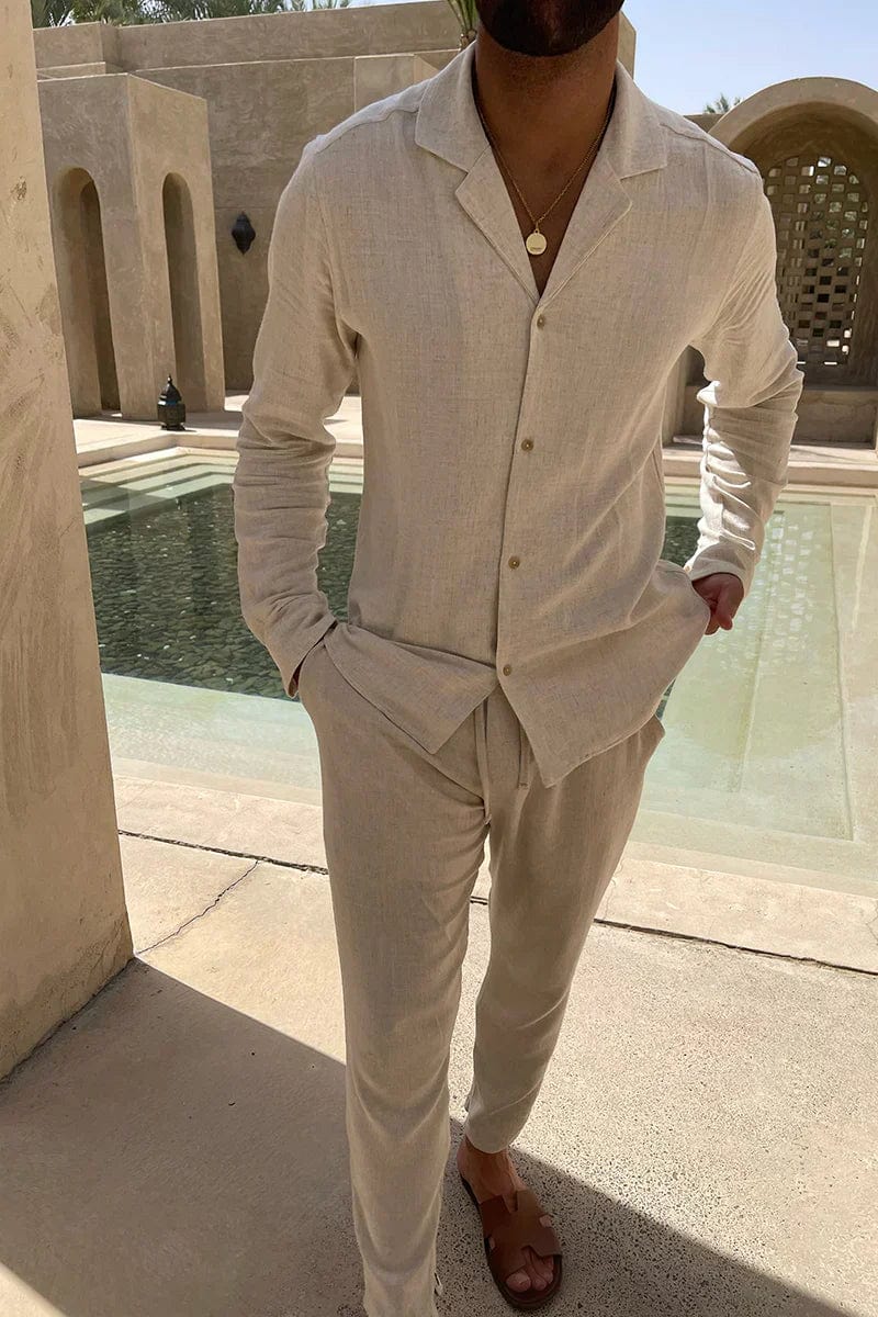 Man wearing Enzo beige cuban collar long sleeve shirt and pants set near a pool
