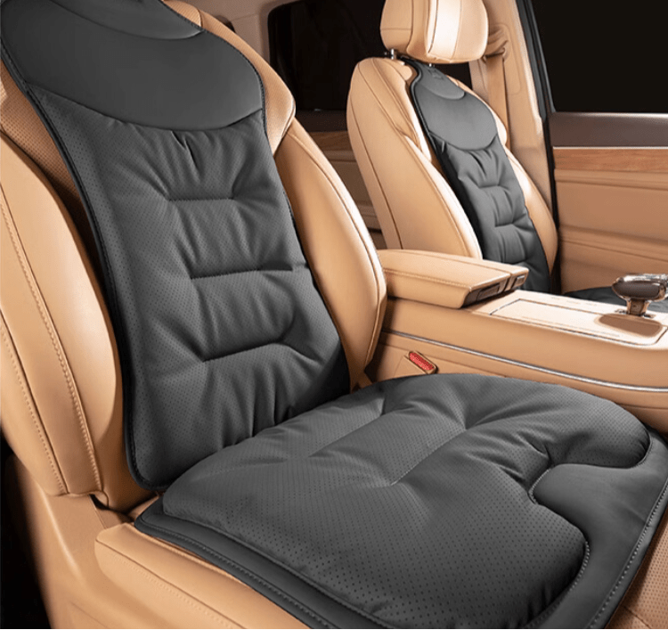 Ergonomic black car back cushion installed on a tan leather vehicle seat