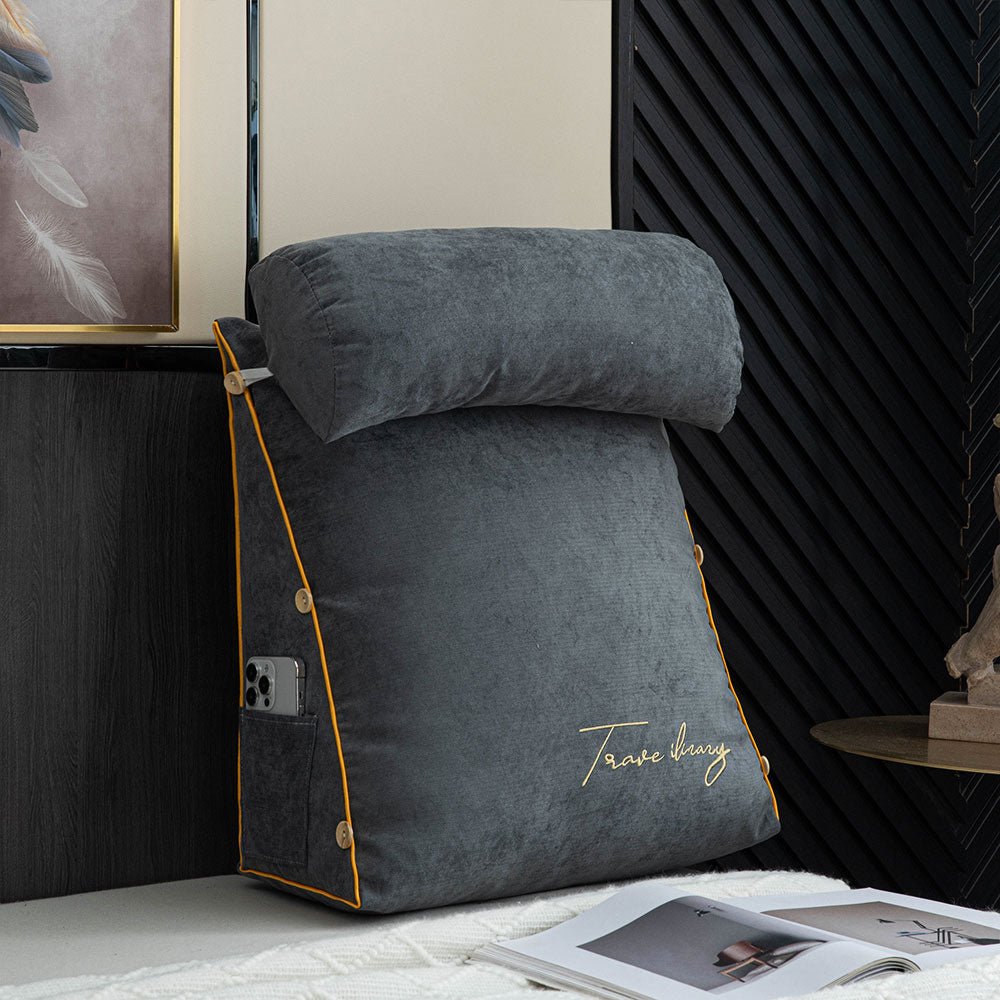Charcoal ergonomic reading pillow with neck roll and side pocket on a bed
