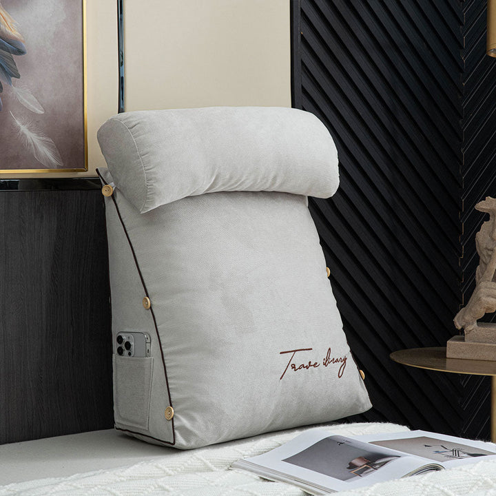 Person relaxing comfortably against ergonomic bed rest pillow