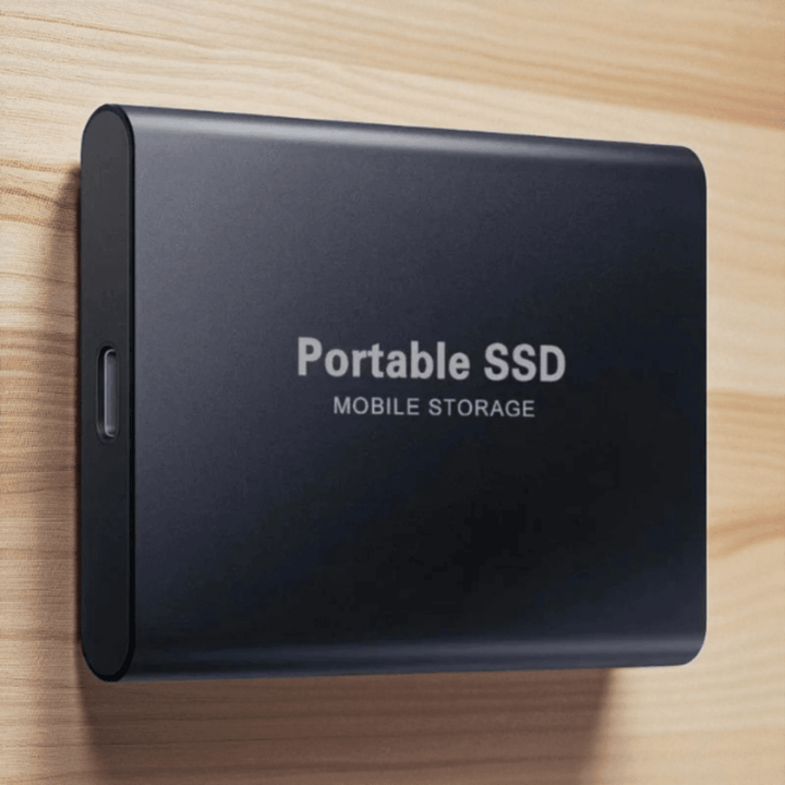 Black portable external SSD resting on a wooden surface with USB-C connection view